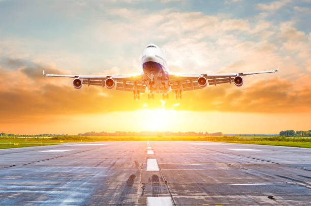 istock Passenger airplane landing at sunset on a runway. 1126769601