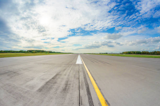 istock Runway clear for take off, airstrip with marking on blue sky with clouds background. Travel aviation concept 1126769722