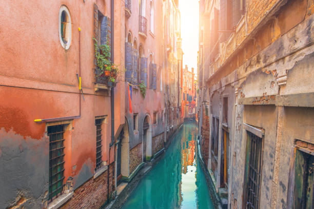 calle muy estrecha y el canal de venecia. - venice gondola fotografías e imágenes de stock