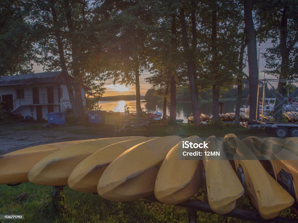 yellow kayaks River Wda, Poland - August 21, 2016:  A view at the sunset above the Goluń lake through yellow kayaks in Wdzydze Kiszewskie. Bory Tucholskie. Above Stock Photo