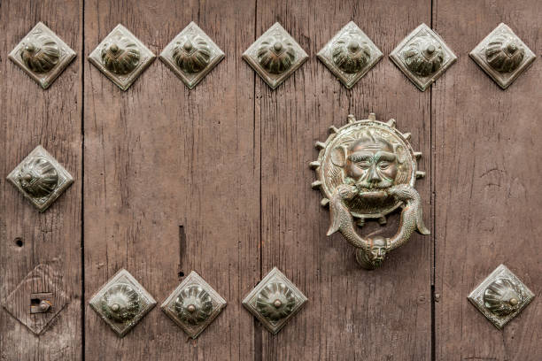 istock Old wooden door with a bronze head and iron rivets 1126776726