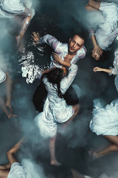 istock Fine art imagery. Selender mythical young beautiful sirens pulling a young attractive guy under the water 1126776863