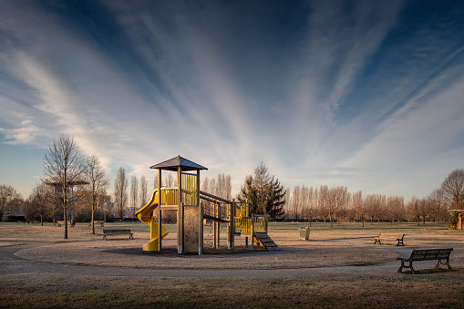 Empty children playground and benches before the sunrise of a winter day