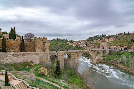 Toledo, Spain; February 2017: the San Martín Bridge is a medieval bridge that crosses the Tagus River as it passes through the monumental city of Toledo
