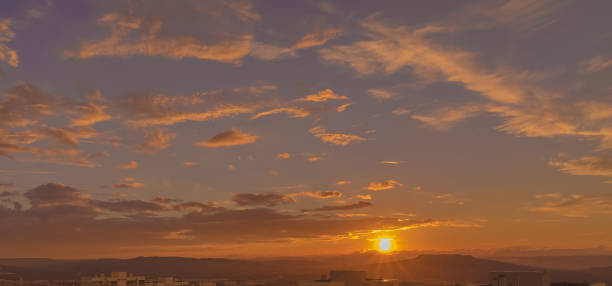 istock sunset scene with sun fall behind the clouds and mountains in background, warm colorful sky with soft clouds 1126796522