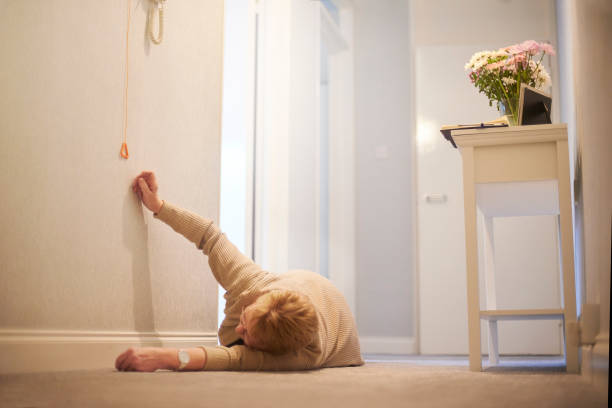 Reaching for emergency cord Senior woman lying on the floor after a fall at home reaching for the emergency pull cord call button stock pictures, royalty-free photos & images