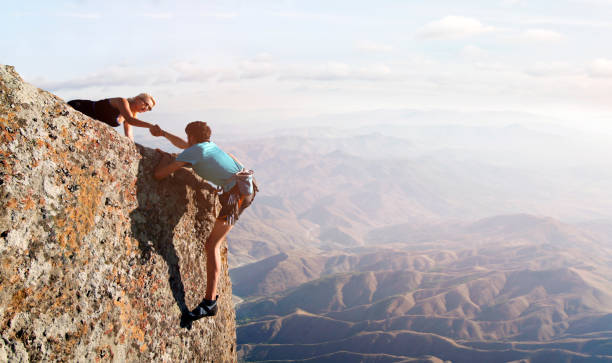 istock Teamwork couple helping hand trust in inspiring mountains 1126797601