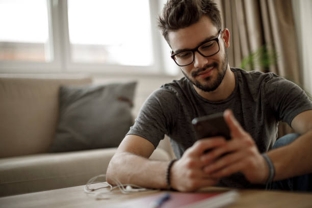 istock Young man using social media at home 1126800344
