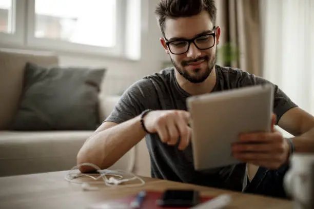 Young man using digital tablet at home