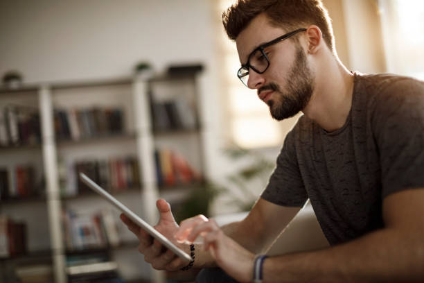 istock Young man using social media at home 1126800610