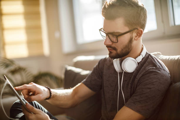 istock Young man using social media at home 1126800641