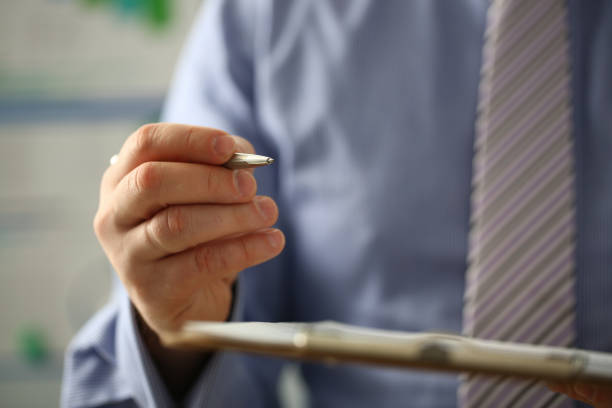 istock Male arm in suit offer contract form on clipboard 1126808974