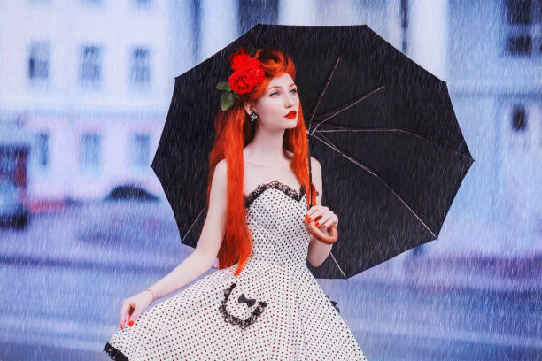 젖은 날씨. 가 비입니다. 폴카 도트 드레스에 외로운 여자 검은 우산을 잡으십시오. 도시에 비가. 젖은 우산 거리의 배경. 여자는 빗 속에서 잡혔다. 외로운 불행 소녀 - wet dress rain clothing 뉴스 사진 이미지