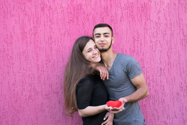 istock Two beautiful lovers holding red heart 1126810963