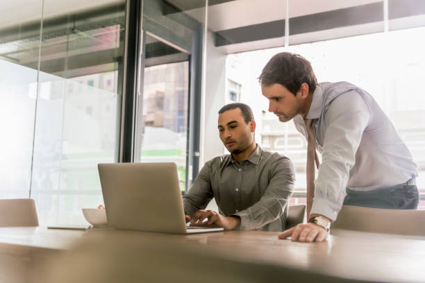 istock Businessmen using laptop at desk in office 1126817507