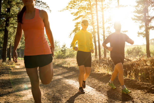 istock Joggers exercising on dirt road amidst trees 1126819330