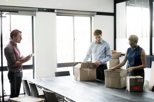 istock Businessman guiding coworkers in packing boxes 1126820160