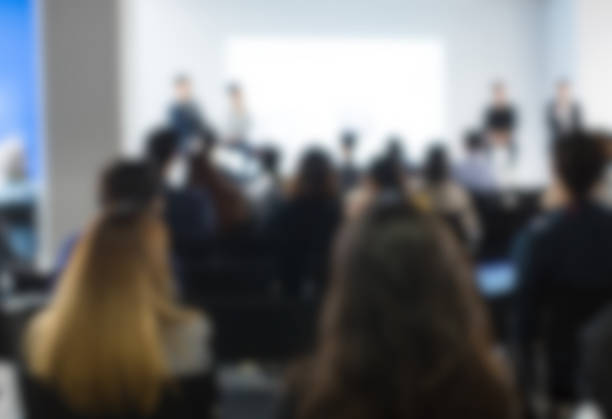 istock Panel Speakers at Corporate Conference Lecture. Blurred De-focused Unidentifiable Presenters and Audience. Corporate Managers Give Presentation to Technology and Real Estate People. 1126820877