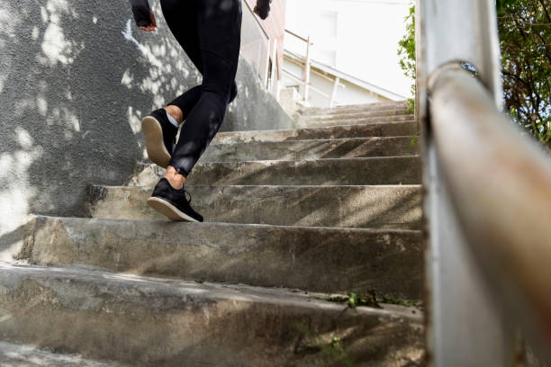 low section of female athlete running on steps - railing beautiful human leg people imagens e fotografias de stock