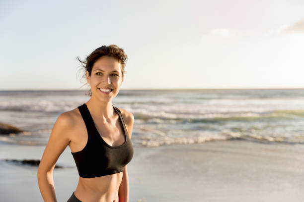 istock Happy female athlete looking away at beach 1126820950