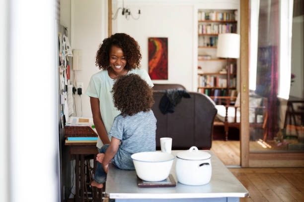 istock Happy woman looking at son sitting on table 1126822551