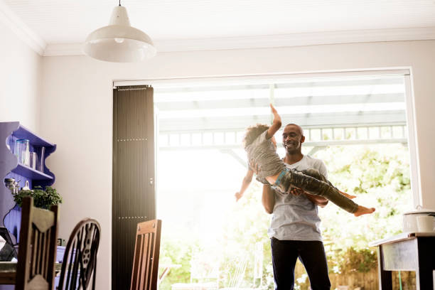 istock Man carrying son at home 1126822789