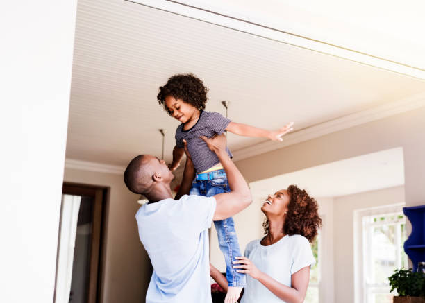 istock Woman looking at man lifting son in house 1126822794
