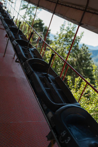 Fun Ride – ‘Toboggan’ down hill Toboggan at Mutianyu Great Wall, Beijing, China – October 7, 2018:  When visiting Mutianyu Great wall in China, you have several options to go up/down the walls. One of them is Toboggan. It is a fun ride to down the hill (no UP).  They are individual carts and you can carry all your stuff on your back or in front, just sit in the small cart and grab the handle(stick). You can control the speed with the stick. If you are too slow, you will have many other riders behind you. When the ride is over, you are back to the entrance at the bottom. mutianyu toboggan stock pictures, royalty-free photos & images