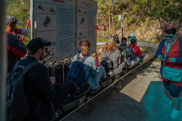 Fun Ride – ‘Toboggan’ down hill Toboggan at Mutianyu Great Wall, Beijing, China – October 7, 2018:  When visiting Mutianyu Great wall in China, you have several options to go up/down the walls. One of them is Toboggan. It is a fun ride to down the hill (no UP).  They are individual carts and you can carry all your stuff on your back or in front, just sit in the small cart and grab the handle(stick). You can control the speed with the stick. If you are too slow, you will have many other riders behind you. When the ride is over, you are back to the entrance at the bottom. mutianyu toboggan stock pictures, royalty-free photos & images