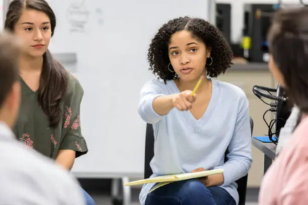 Photo of Teen girl takes question during serious high school study group