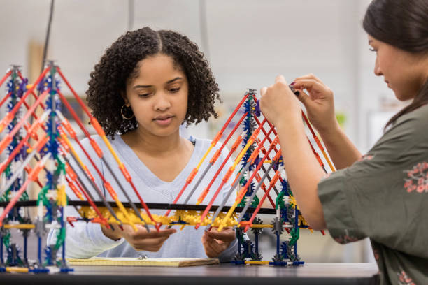 Teen girls build bridge at school using model kit
