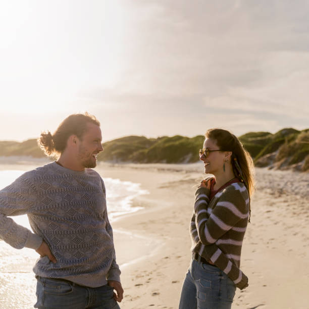 istock Happy young couple standing at beach 1126828984