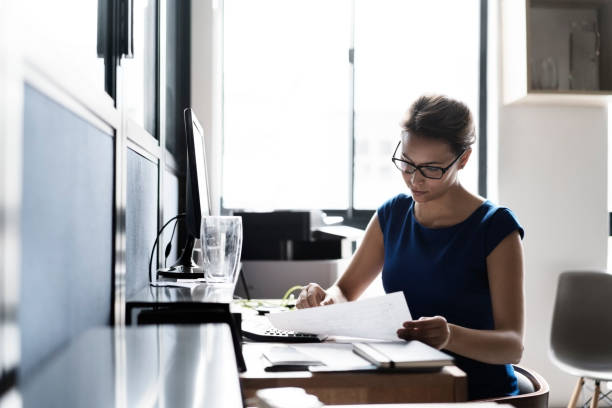 istock Serious businesswoman working at brightly lit desk 1126829834