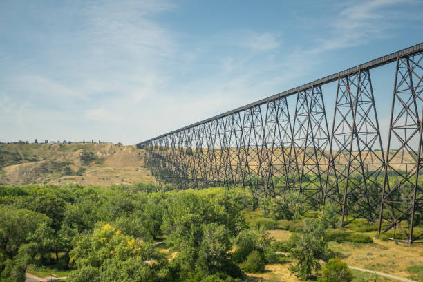 railway bridge crossing a river to the horizon railway bridge and stair case footpath meeting at horizon in Lethbridge lethbridge alberta stock pictures, royalty-free photos & images