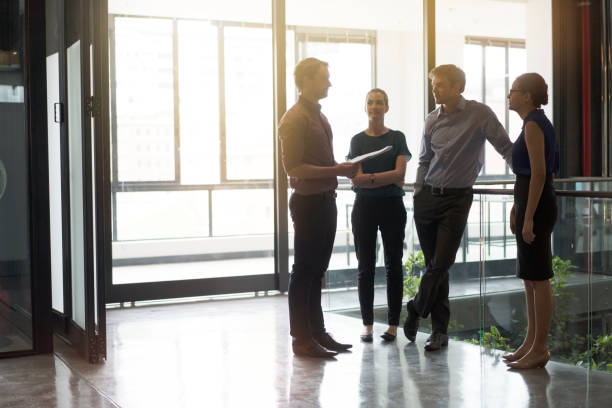 istock business colleagues discussing at office corridor 1126831237