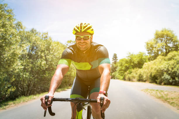 istock Happy cyclist riding bicycle on country road 1126832933