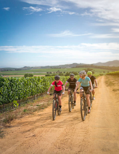 istock Cyclists riding bicycles on dirt road against sky 1126832960