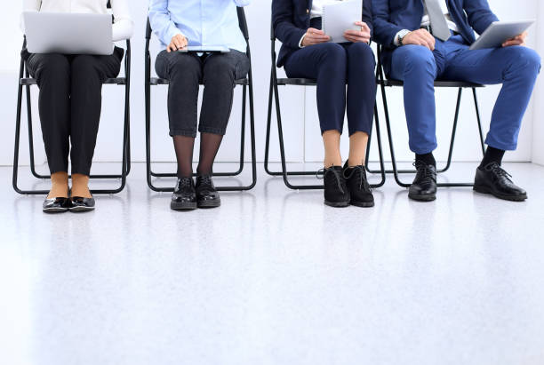 istock Group of business people sitting in office and waiting for job interview while using gadgets, close-up. Conference or training concepts 1126837757