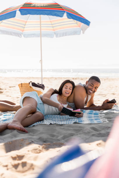 istock Happy couple lying on blanket at beach 1126838571