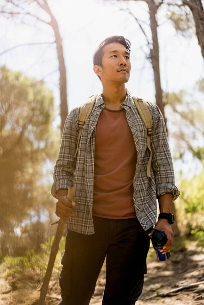 istock Young man hiking in forest on sunny day 1126839861