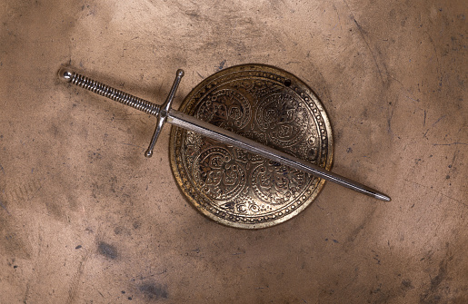 medieval shield and sword on a gold background