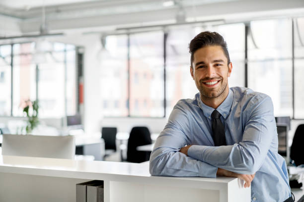 istock Smiling businessman leaning on cubicle in office 1126841678