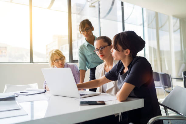 istock Businesswomen using laptop together in board room 1126842638