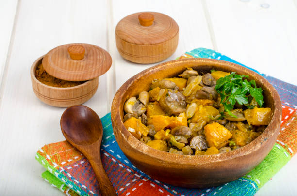 Wooden bowl with vegetable stew with mushrooms. Studio Photo