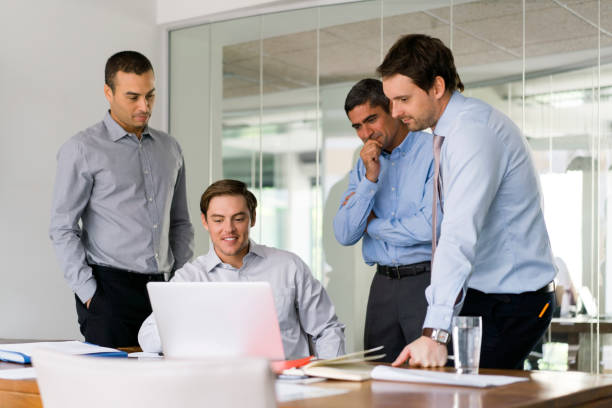 Businessman with colleagues discussing over laptop