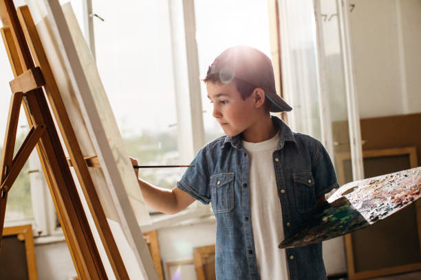 istock Schoolboy painting on canvas 1126845439