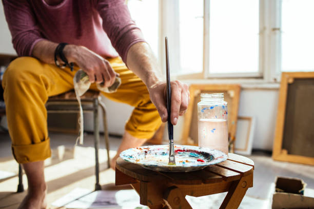 istock Guy mixing painting colors in an art studio 1126845642