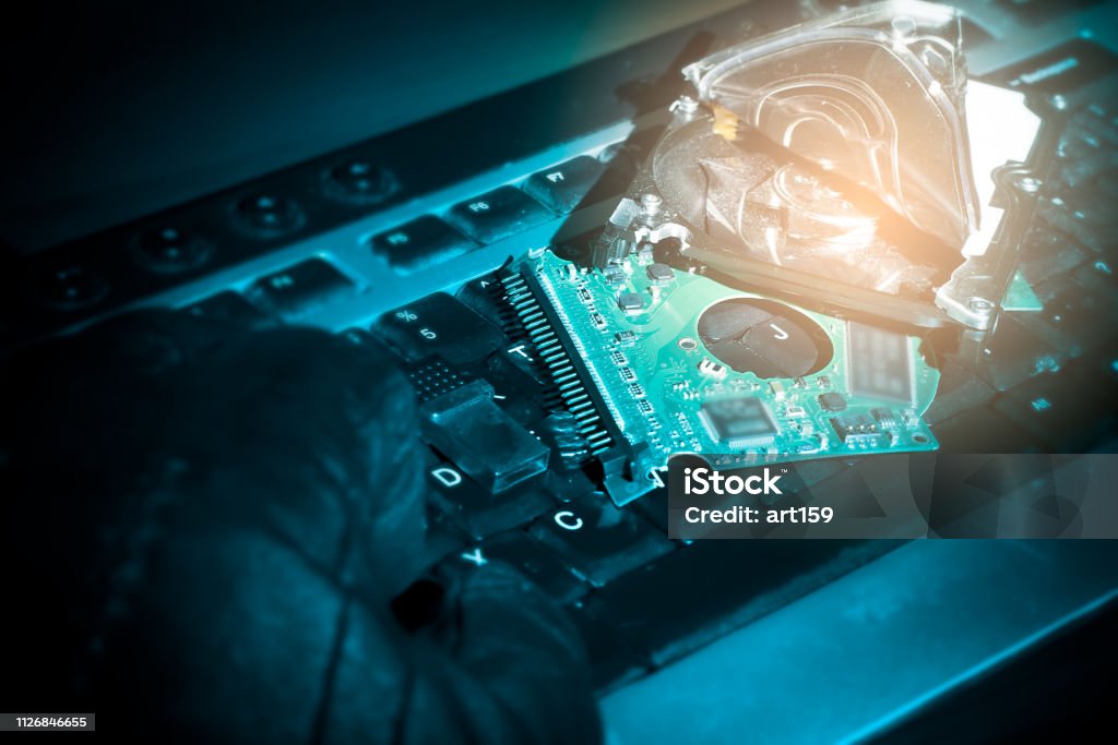 hacker hand on a keyboard. hacked computer hard drive, cybercrime concept Blue Stock Photo