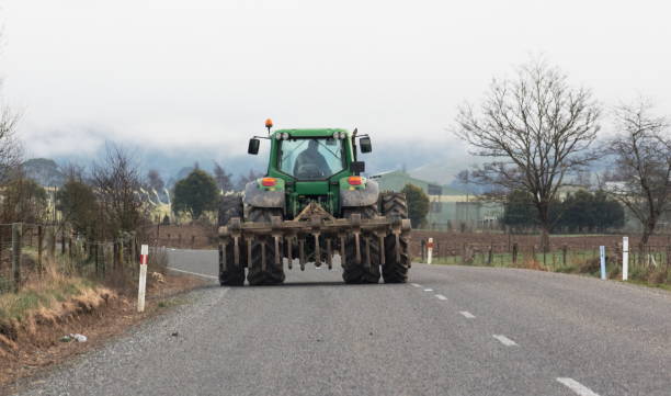 A Tractor been driven on a New Zealand rural road stock photo