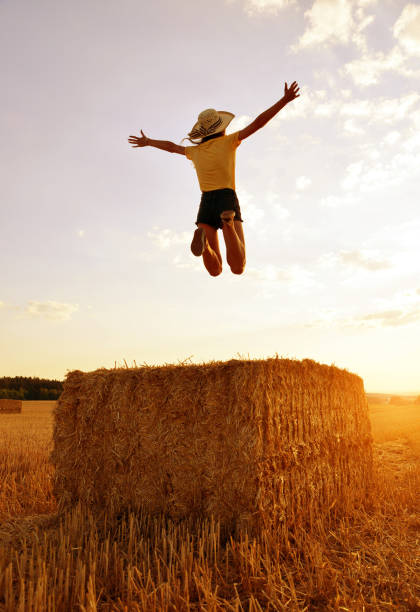 istock Girl jumping on a straw bale. 1126849757